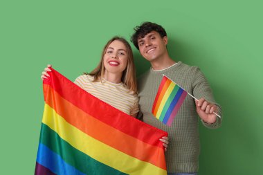 Yeşil arka planda LGBT bayrakları olan genç bir çift