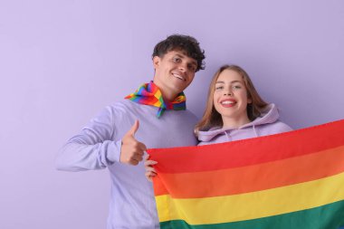Leylak arka planında LGBT bayrağı olan genç bir çift.