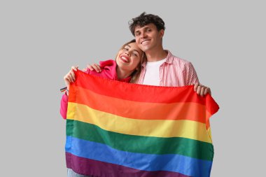 Açık arkaplanda LGBT bayrağı olan genç bir çift