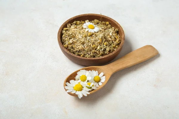 stock image Bowl of dried and fresh chamomile flowers on light background