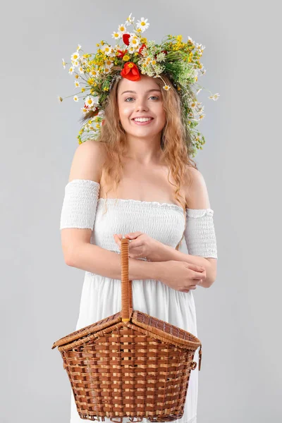Schöne Junge Frau Blumenkranz Und Mit Korb Auf Hellem Hintergrund — Stockfoto