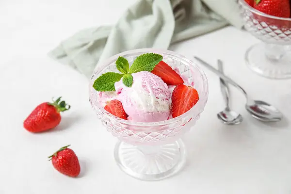 stock image Glass bowl of strawberry ice cream on white table, closeup