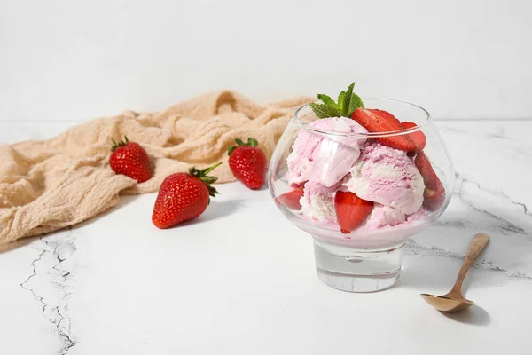 玻璃碗里的草莓冰淇淋和勺子放在桌上 — 图库照片
