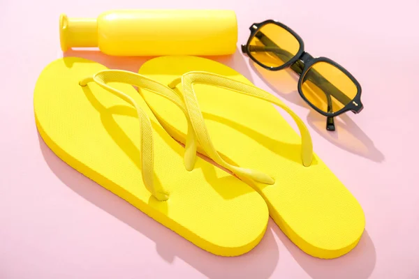 Eine Flasche Sonnencreme Mit Sonnenbrille Und Flip Flops Auf Rosa — Stockfoto
