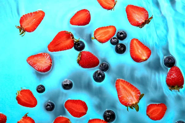 Snijd Verse Aardbeien Bosbessen Water Blauwe Achtergrond — Stockfoto