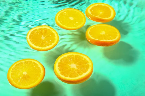 Кусочки Свежего Апельсина Воде Бирюзовом Фоне — стоковое фото