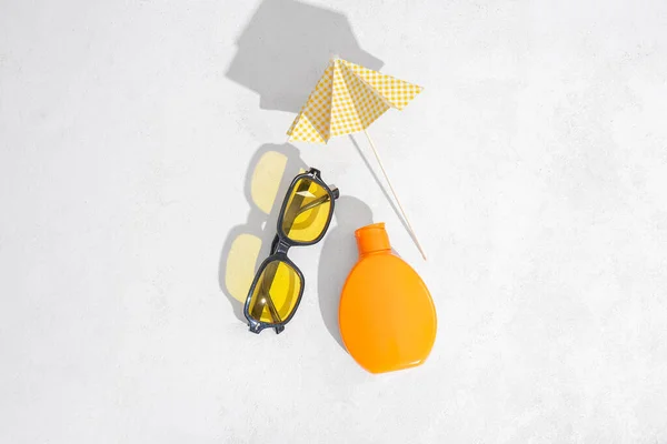 Bottiglia Crema Solare Occhiali Sole Ombrello Sfondo Chiaro — Foto Stock