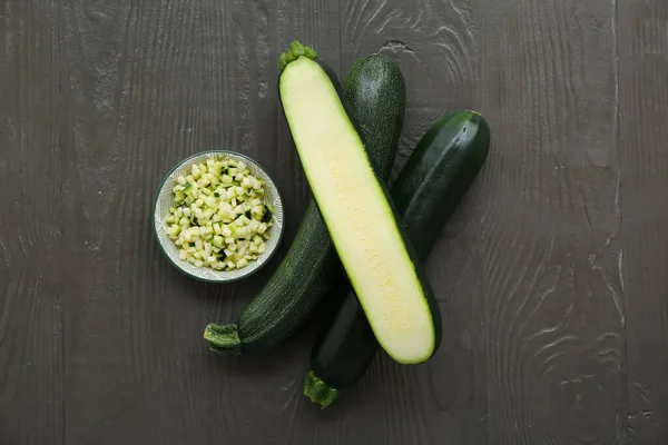 Frische Grüne Zucchini Und Teller Mit Scheiben Auf Schwarzem Holzhintergrund — Stockfoto