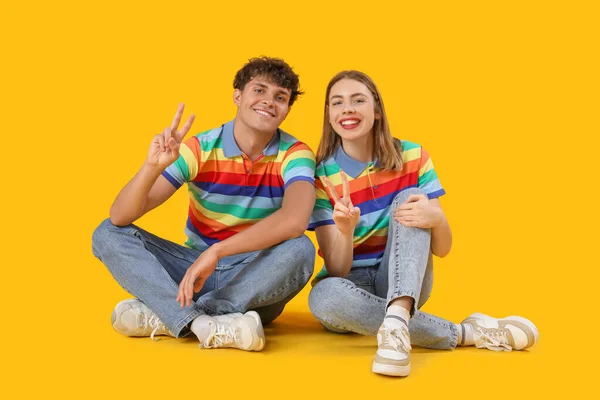 Young Couple Rainbow Shirts Showing Victory Gesture Yellow Background — Stock Photo, Image