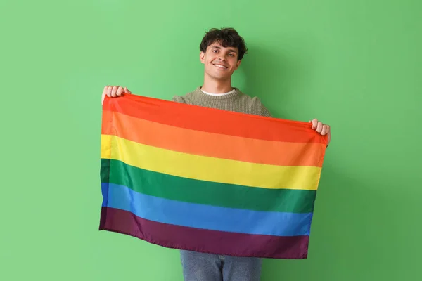 緑の背景にLgbtの旗を持つ若い男 — ストック写真
