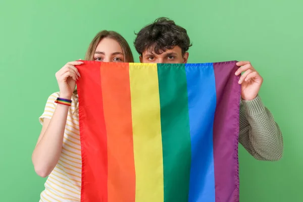 緑の背景にLgbtの旗を持つ若いカップル — ストック写真