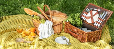 Parkta romantik piknik için lezzetli yiyecek ve içecek ile Hasır sepetler