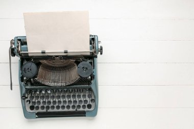 Beyaz ahşap masa üzerinde boş kağıt levha ile klasik daktilo