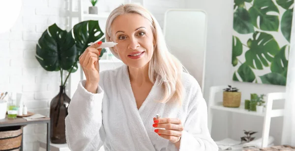 Pretty Mature Woman Applying Eye Cream Bathroom — Stock Photo, Image