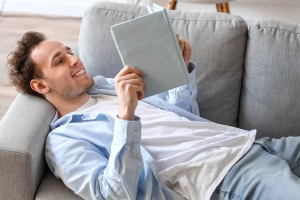 Young Man Reading Book Sofa Home — Stock Photo, Image
