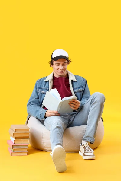 若い男読書本に黄色の背景 — ストック写真