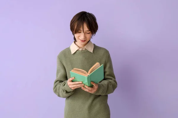 Remaja Laki Laki Membaca Buku Pada Latar Belakang Ungu — Stok Foto