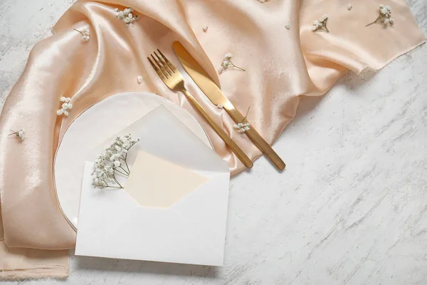 白いテーブルの上に白い招待状カード カトラリー ジプシーの花できれいなプレート — ストック写真