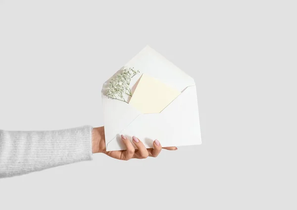 白い背景に白い招待状カードとジプシーの花と封筒を保持する女性 — ストック写真
