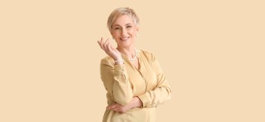 Güzel, mutlu, olgun bir kadın bej arka planda