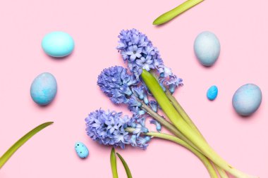 Beautiful hyacinth flowers and Easter eggs on pink background