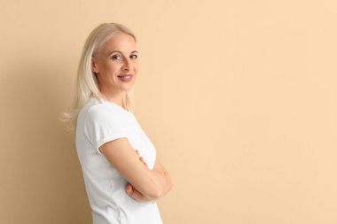 Mature blonde woman on beige background