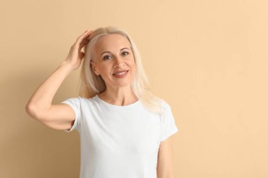Mature blonde woman on beige background