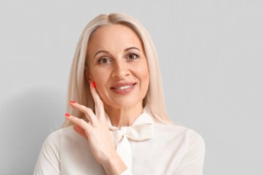 Açık arka planda olgun sarışın kadın, yakın plan.