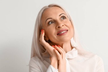 Açık arka planda olgun sarışın kadın, yakın plan.