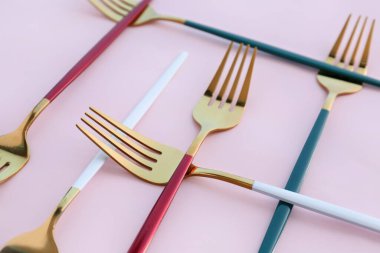 Pembe arka planda altın çatallar