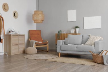 Gri kanepesi ve koltuğu olan aydınlık oturma odasının içinde.