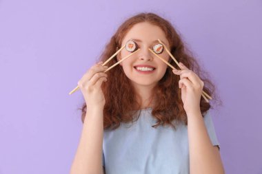 Leylak arkaplanda suşi yuvarlayan genç bir kadın.