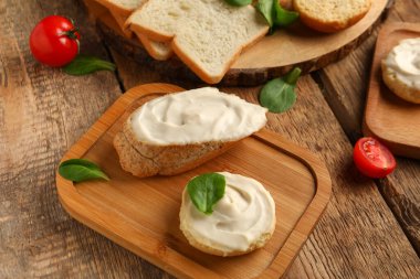 Ahşap arka planda krem peynirli lezzetli bruschetta ve kızarmış ekmek.