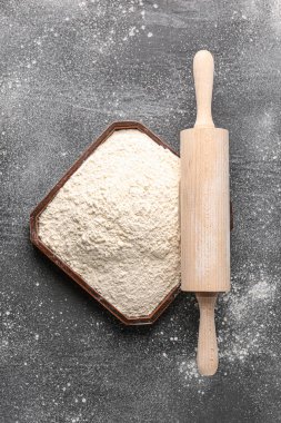 Buğday unlu tabak ve grunge siyah arkaplanda merdane.