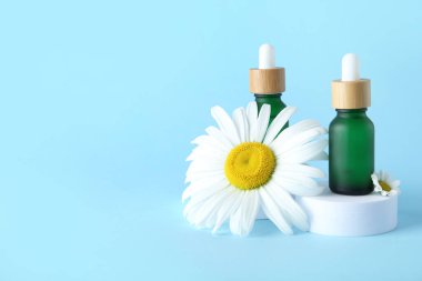 Renkli arka planda gerekli yağ şişeleri ve papatya çiçekleri kompozisyonu