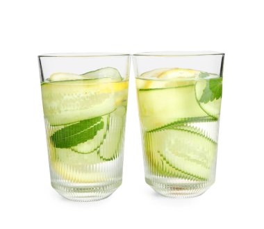 Beyaz arka planda salatalık dilimleri ile doldurulmuş su bardakları