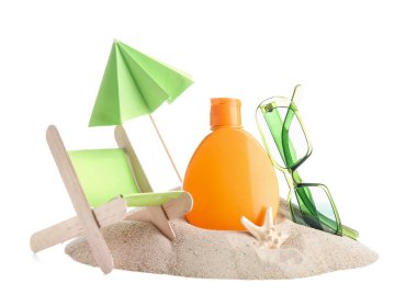 Güneş kremi şişesi, minyatür iskemle ve beyaz arka planda kumdaki güneş gözlüğü ile yaratıcı kompozisyon