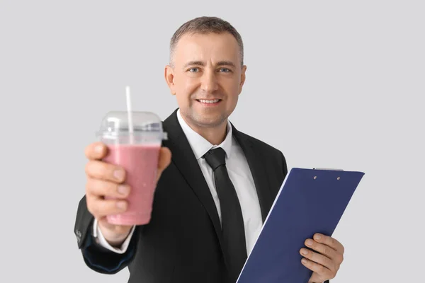 Reifer Geschäftsmann Mit Glas Frucht Smoothie Und Klemmbrett Auf Hellem — Stockfoto