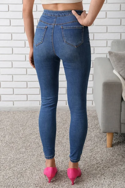 Jovem Mulher Jeans Elegantes Sofá Perto Parede Tijolo Leve Quarto — Fotografia de Stock