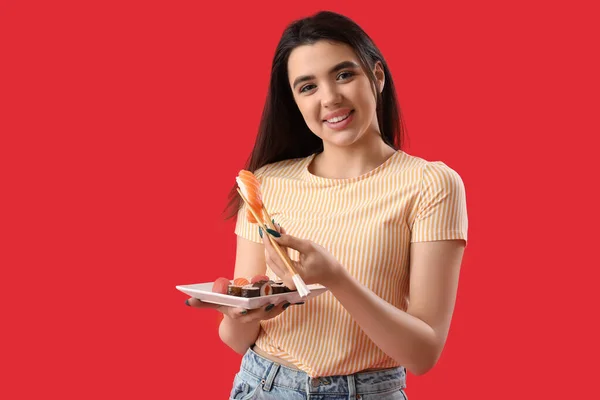 Young Woman Sushi Rolls Chopsticks Red Background — Stock Photo, Image