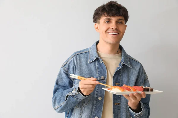 Ung Man Med Sushi Ljus Bakgrund — Stockfoto