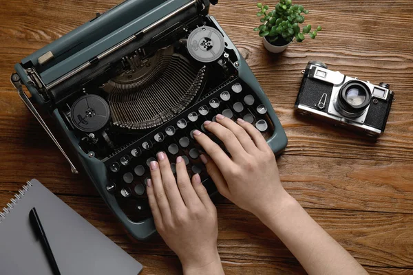 Vrouw Typen Typemachine Met Kamerplant Camera Notebook Bruine Houten Achtergrond — Stockfoto
