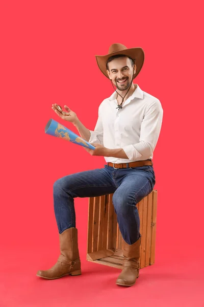 Knappe Cowboy Met Kompas Wereldkaart Zittend Rode Achtergrond — Stockfoto
