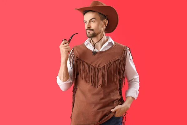 Schöner Cowboy Mit Rauchender Pfeife Auf Rotem Hintergrund — Stockfoto