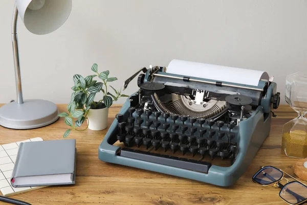 Vintage Γραφομηχανή Κλεψύδρα Λάμπα Και Σημειωματάρια Καφέ Ξύλινο Τραπέζι Κοντά — Φωτογραφία Αρχείου