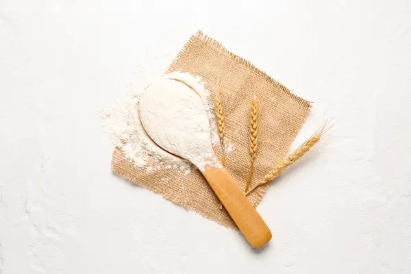 白い背景に小麦粉と小麦の耳を持つ木製のスプーン — ストック写真
