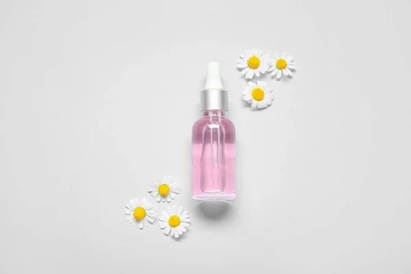 Komposition Mit Einer Flasche Ätherischem Und Kamillenblüten Auf Weißem Hintergrund — Stockfoto