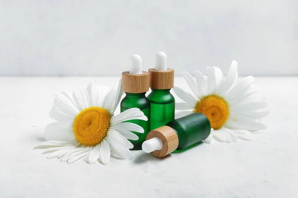 Bottles Essential Oil Beautiful Chamomile Flowers Light Background — Stock Photo, Image
