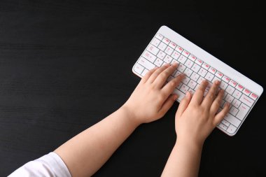 Koyu arkaplanda modern bilgisayar klavyesine sahip kadın elleri
