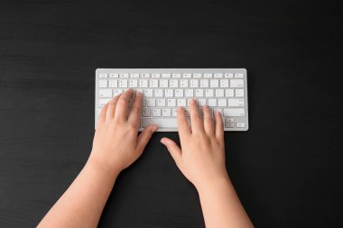 Koyu arkaplanda modern bilgisayar klavyesine sahip kadın elleri
